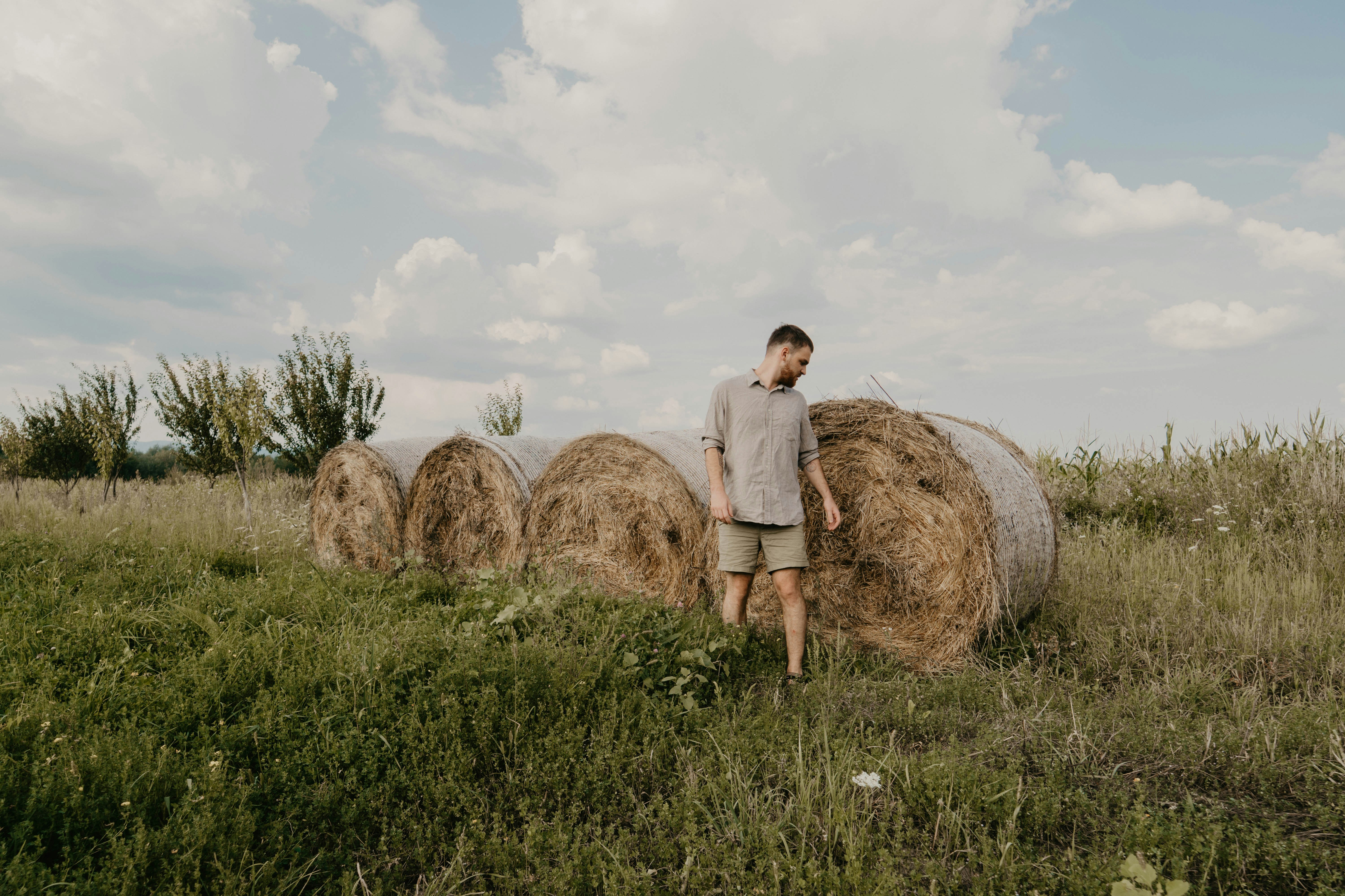 man standing near the stock hay